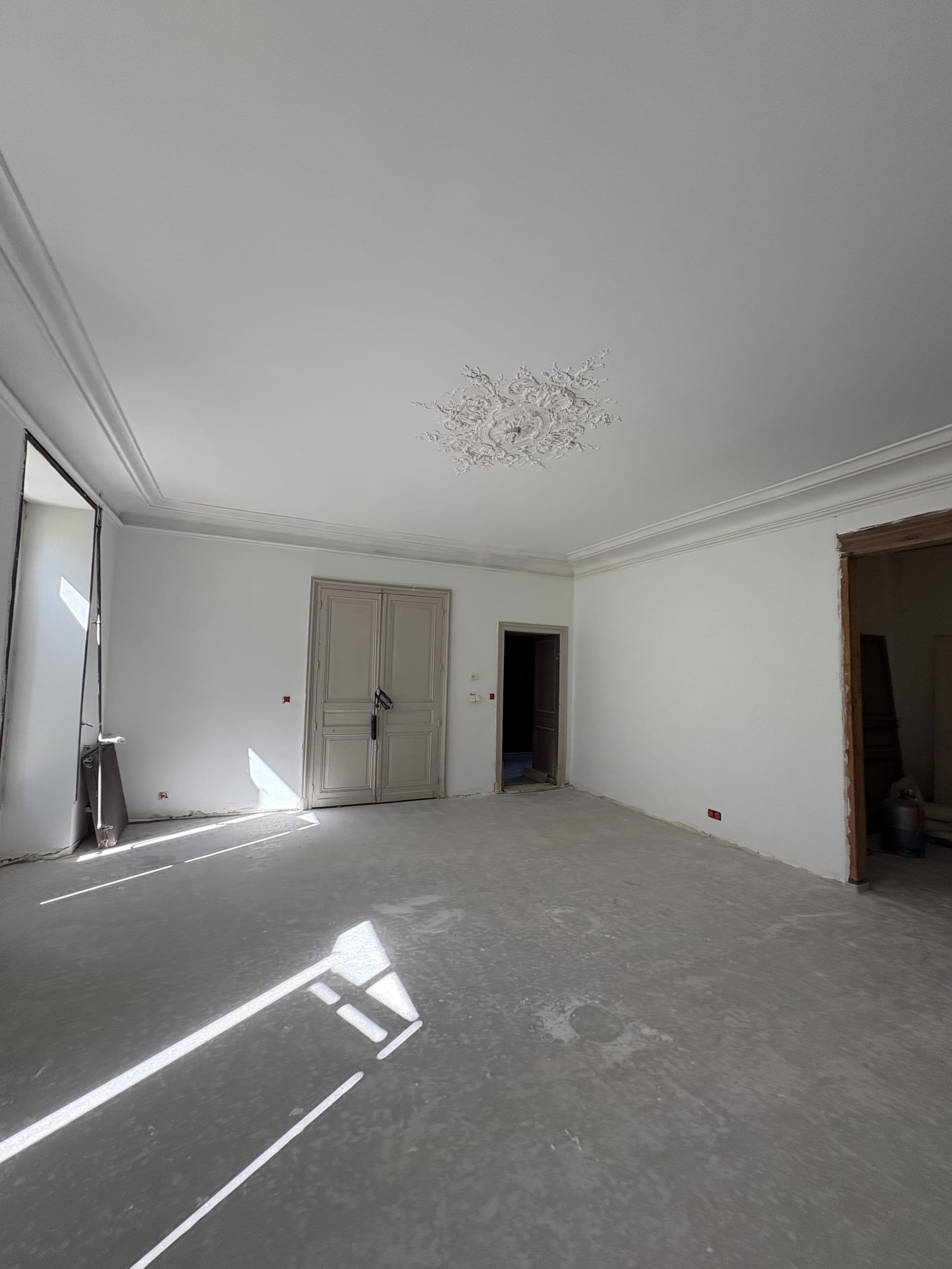 Pièce rénovée en blanc, moulures et rosaces mises en valeur, peintre à Bourges (18)