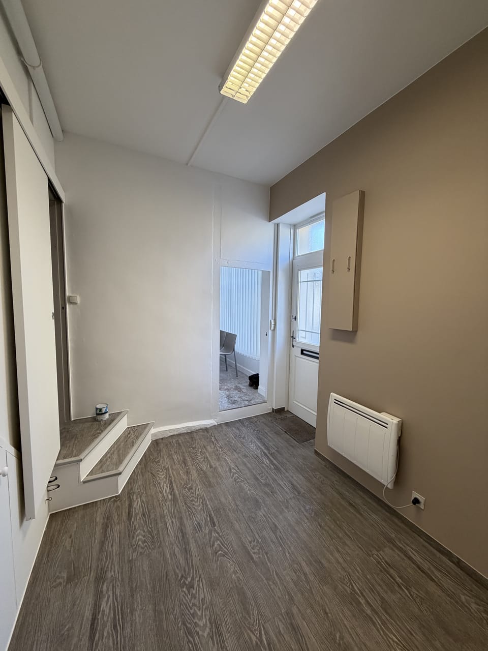 Entrée rénovée avec mur taupe et parquet, peintre en bâtiment à Bourges (18)
